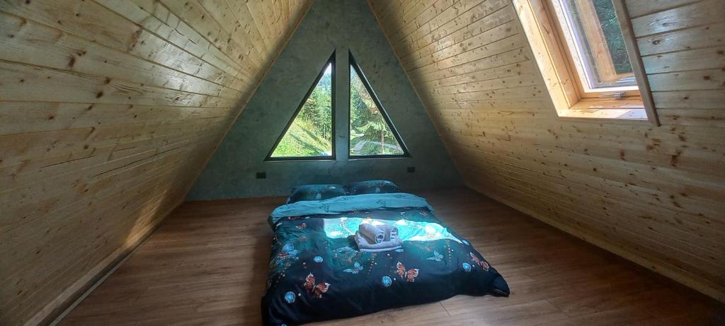 a room with a bed in a tiny house at Cabana Doi Brazi A-FRAME in Dămuc