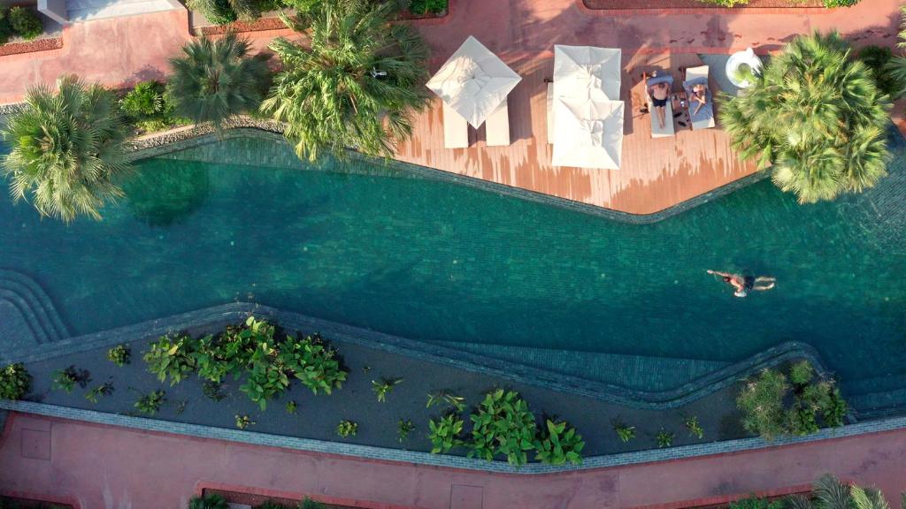 eine Draufsicht auf einen Swimmingpool mit Palmen in der Unterkunft TUI BLUE Angkor Grace Wellness Resort in Siem Reap