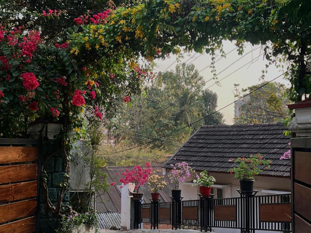 a garden with flowers in pots on a fence at Little Chandhana Guest House in Kottayam