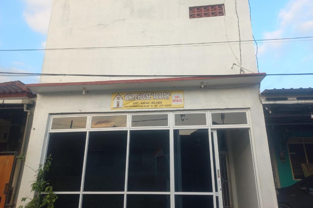 a building with a large window with a sign on it at OYO 94771 White House Arafah Syariah in Purwokerto