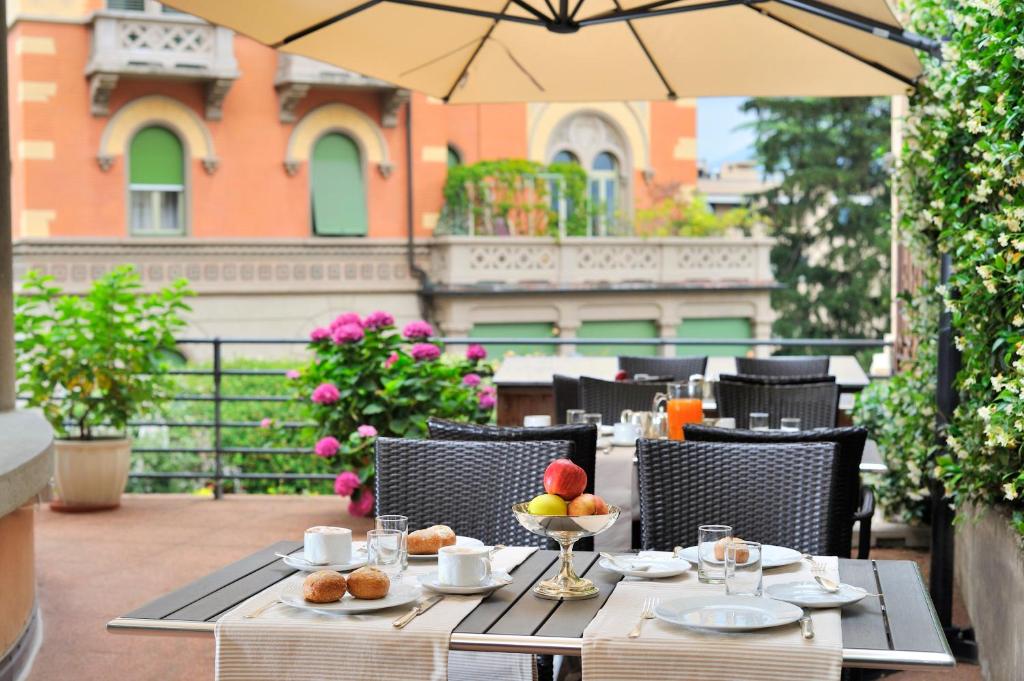 a table with a bowl of fruit on a patio at Hotel Federale in Lugano