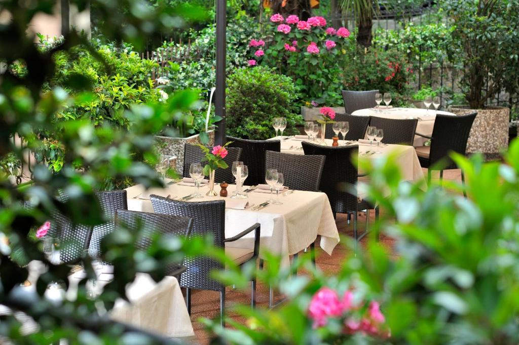 a group of tables with wine glasses and flowers at Hotel Federale in Lugano