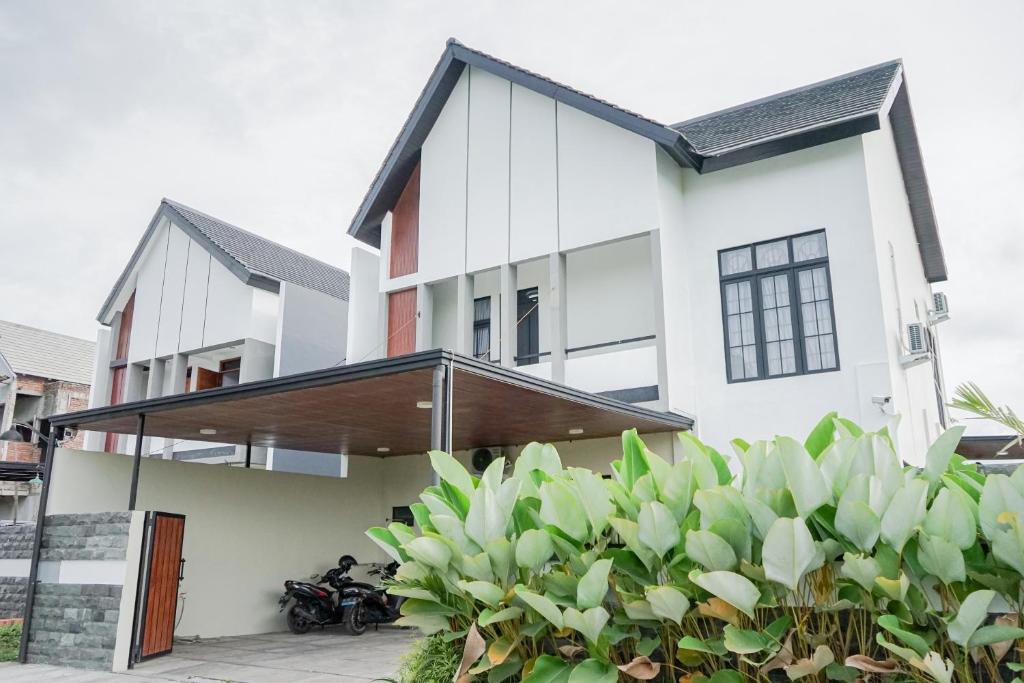 a white house with a black roof at Villa Asana Kolam Renang Private in Godean