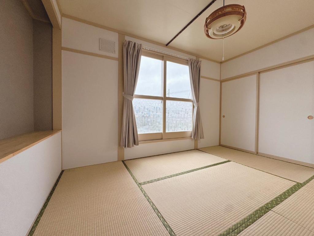 an empty room with a large window and white walls at ''内装フルリフォーム'' HOKKAIDO l 千歳空港まで30分 l 一棟貸し8名迄OK l 白樺 Shirakaba in Yuni