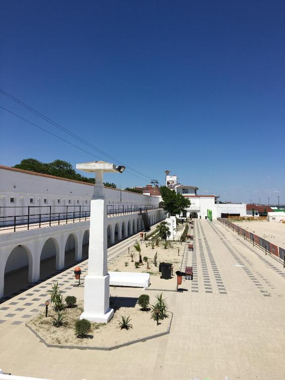 a white pole with an umbrella on a sidewalk at Hostel Cazino Sud in Mamaia
