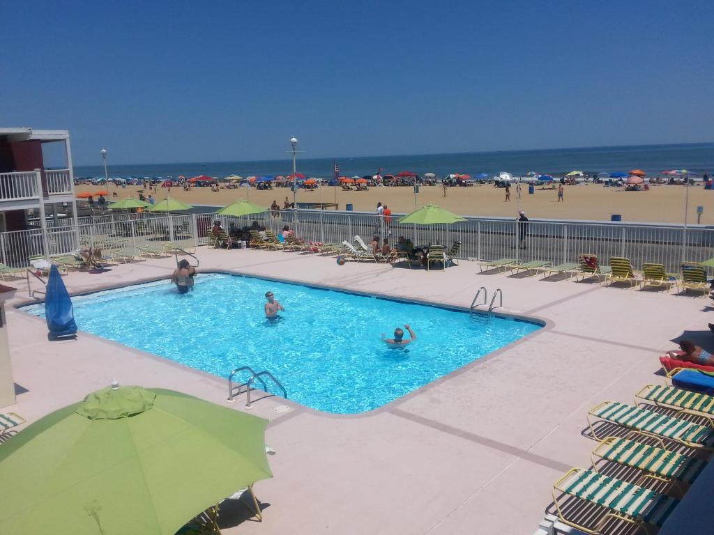 a swimming pool at the beach with people in it at Fish Tales Boardwalk Inn & Ocean Mecca Motel in Ocean City