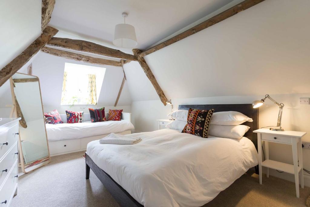 a bedroom with a large bed and a mirror at The Holford Arms in Tetbury