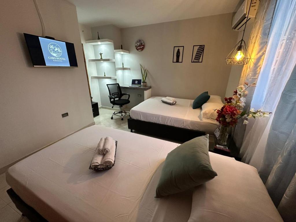 Una habitación de hotel con dos camas y un televisor. en CABO HoSTEL, en Ríohacha