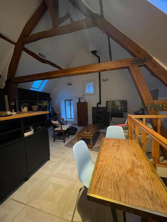 a kitchen and living room with a wooden table and chairs at loft à la campagne in Vermenton