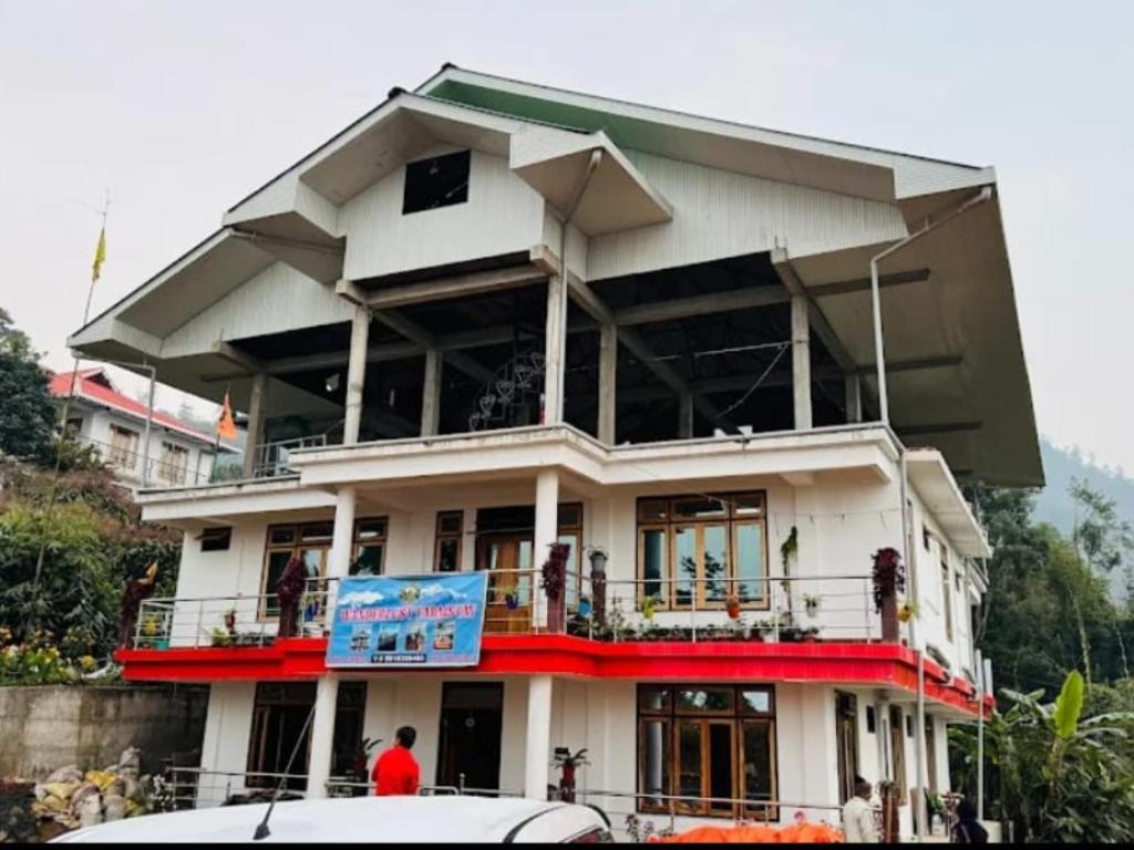 a large white building with a sign in front of it at Wanderlust Homestay By StayApart in Kalimpong