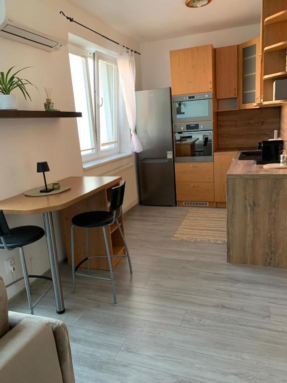 a kitchen with a table and a refrigerator at Apartmán Centrum in Šamorín