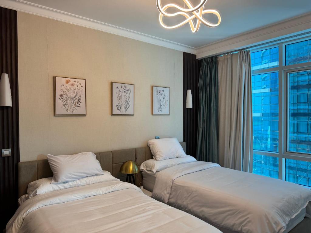 a hotel room with two beds and a window at شقه فندقيه نيل هلتون ريزيدنس المعادي in Cairo