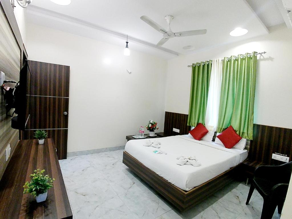 a bedroom with a bed and a green curtain at Hotel Sai SK Palace in Shirdi