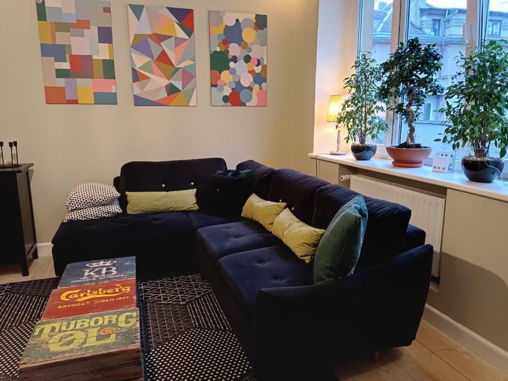 a living room with a blue couch with yellow pillows at Kaunas Inn Colors in Kaunas