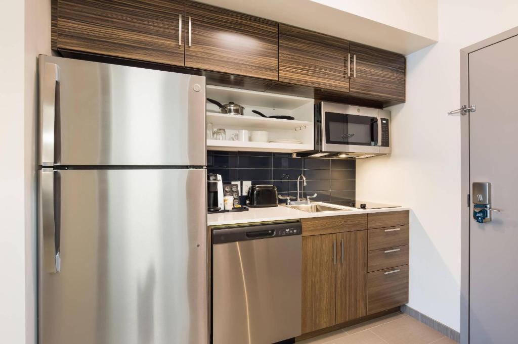 Una cocina con frigorífico de acero inoxidable y fregadero. en MainStay Suites Gaylord, en Gaylord
