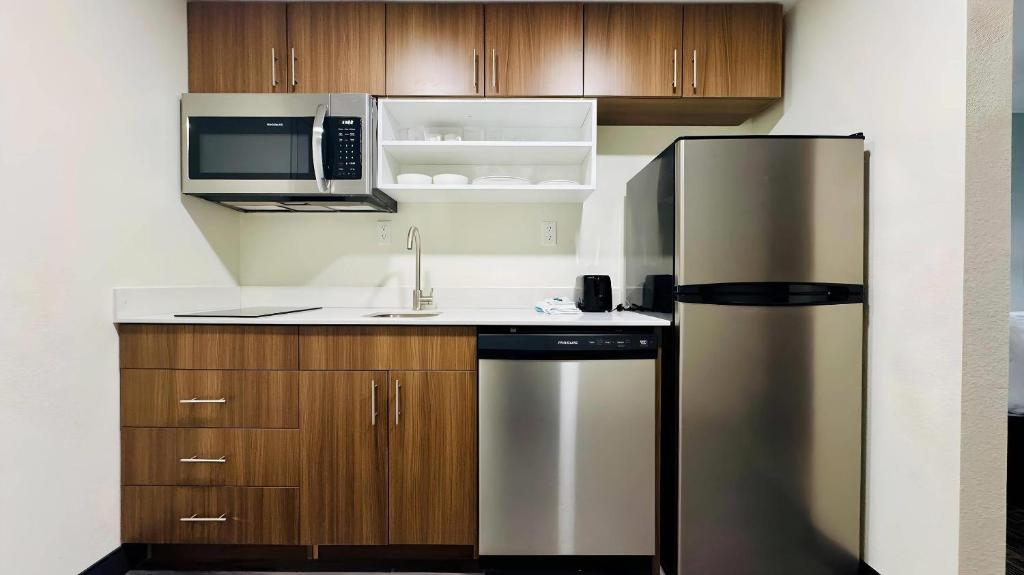 Una cocina con refrigerador de acero inoxidable y microondas. en MainStay Suites Chambersburg, en Chambersburg