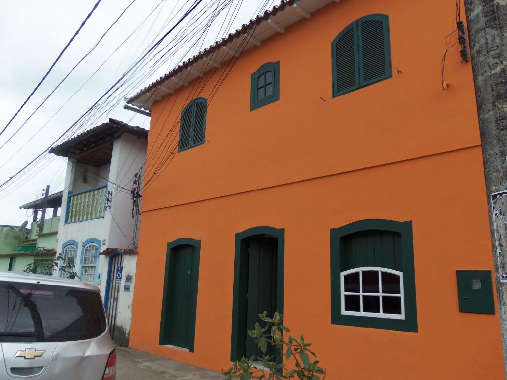 een oranje gebouw met groene luiken op een straat bij Sobrado Paraty in Paraty