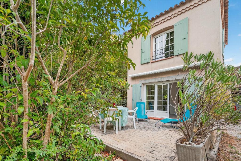 un patio con tavolo e sedie davanti a una casa di Var Hyères Studio bord de mer a La Garde