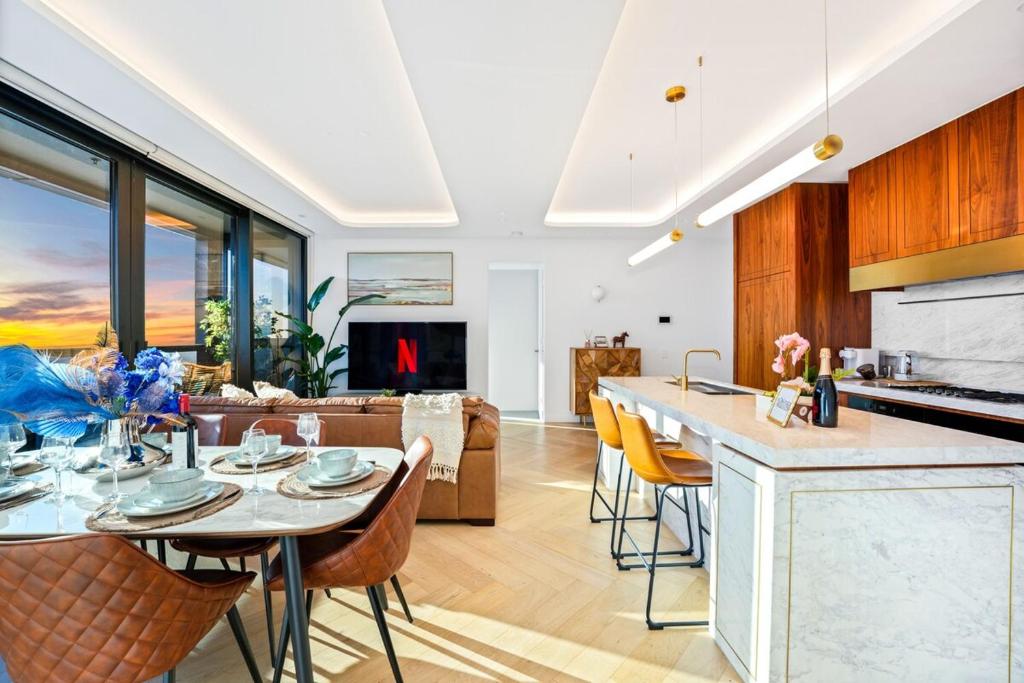 Highrise Luxury Penthouse with City Ocean Mountain View في بوكسهل: مطبخ وغرفة معيشة مع طاولة وكراسي