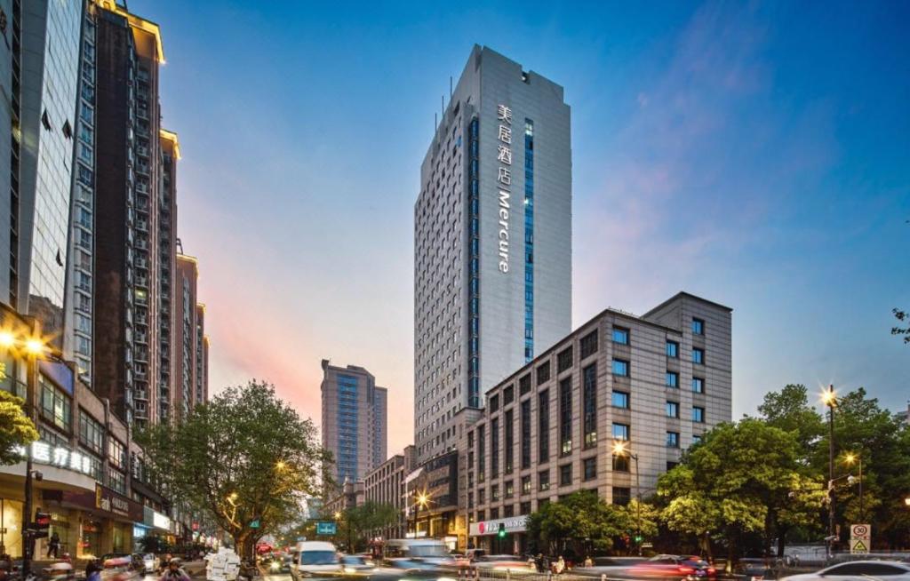 Un palazzo alto in una città con le auto in strada di Orange Crystal Hotel Nanjing Drum Tower a Nanjing