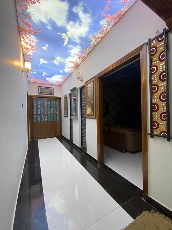 una stanza con un soffitto con un murale di nuvole di Highland Lodge a Karachi