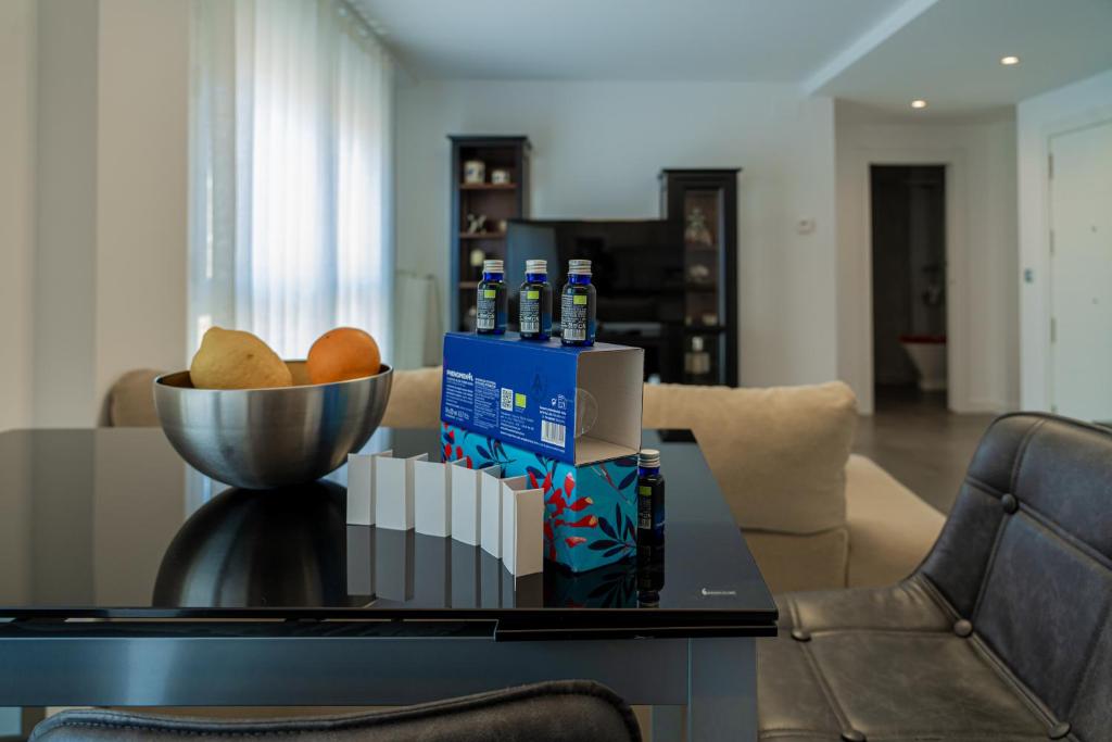 a table with a bowl of bread and bottles of soda at Piso-loft AOVE pleno centro in Jaén