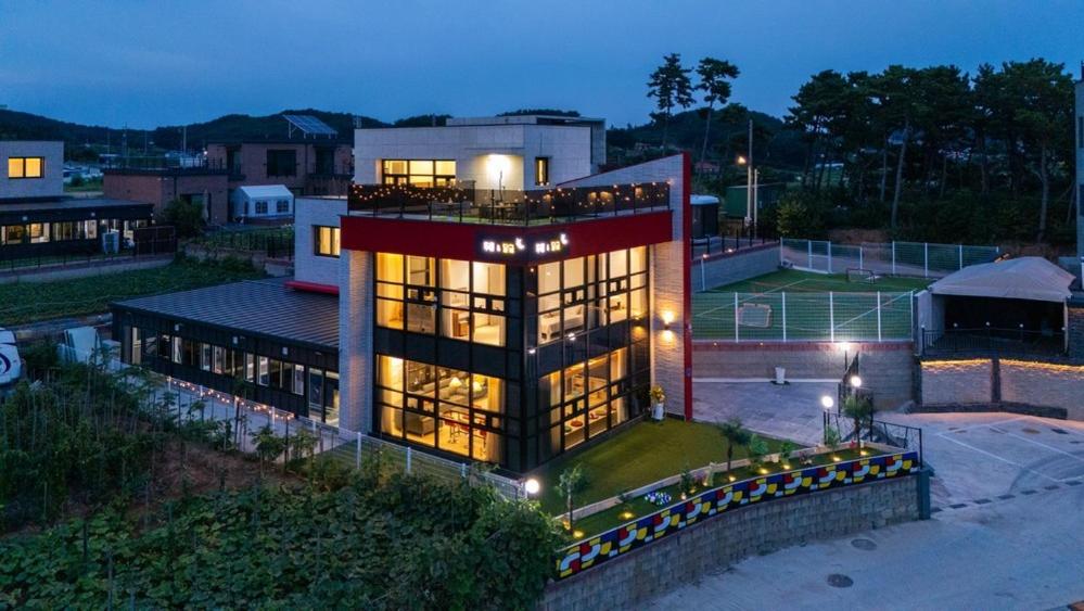 a large building with a lot of windows at night at Daebudo DuMong DalGeum Pool Villa in Ansan