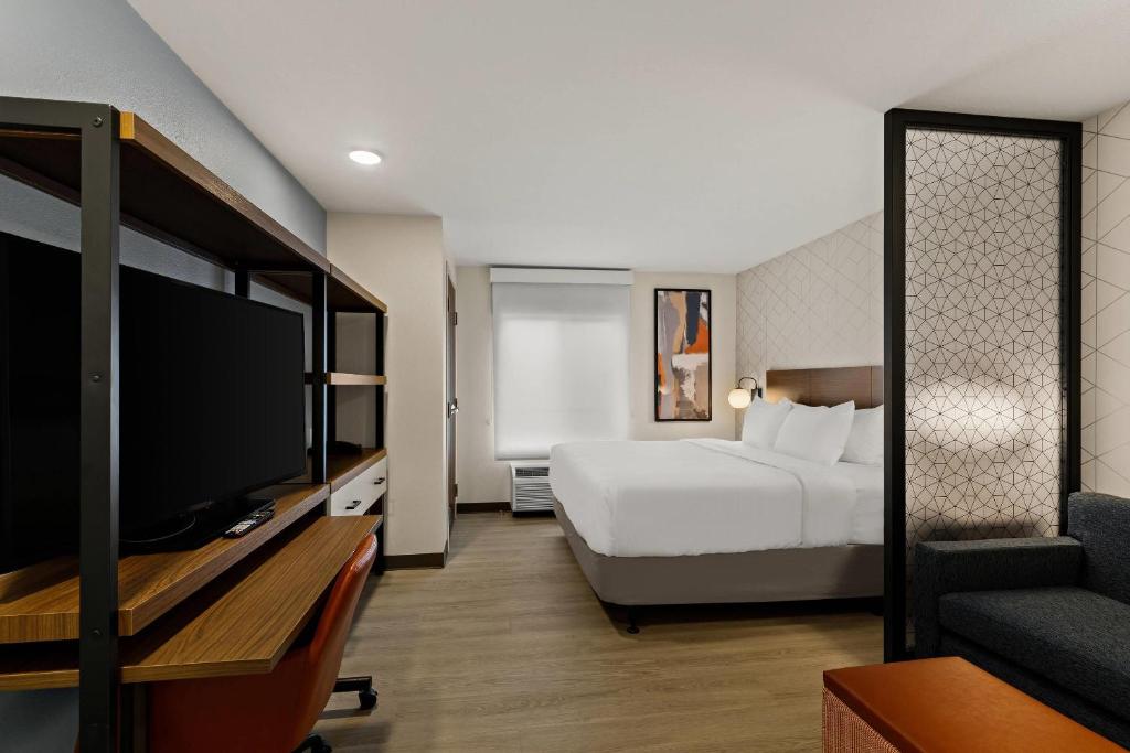 a hotel room with a bed and a flat screen tv at Everhome Suites Portsmouth - Newington in Newington