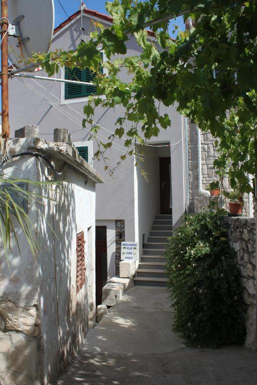 a white building with stairs leading to a door at Apartman Kristina, studio i soba in Primošten