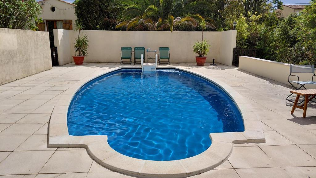 a swimming pool in a patio with chairs and a table at Gite Mimosa - Private Pool, Sainte-Valière, South of France in Sainte-Vallière
