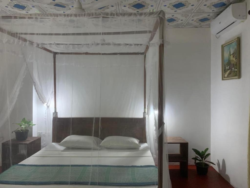 een slaapkamer met een hemelbed bij Lakshmi Villa in Aluthgama