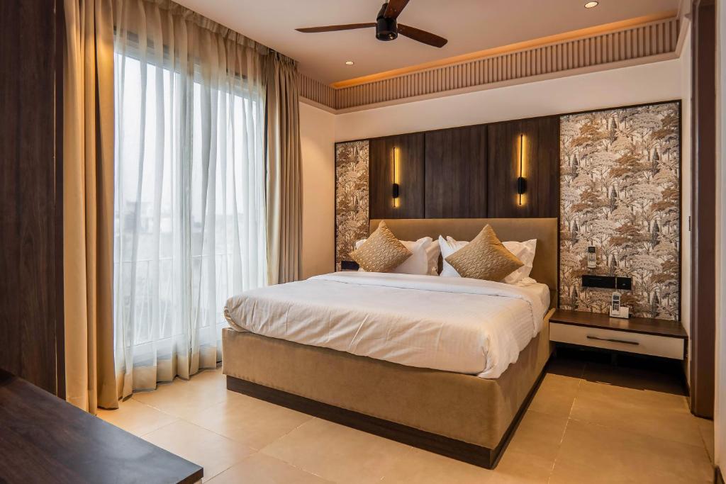 a bedroom with a large bed and a large window at Micasa Suites in New Delhi