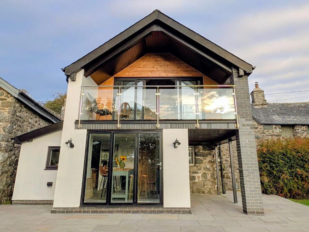 a house with a large window on top of it at Ty Isaf Welsh Farmhouse with Sea Views in Llanddwywe