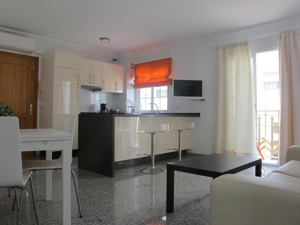 a kitchen and living room with a couch and a table at Apartamentos Jimmy 2 in Nerja