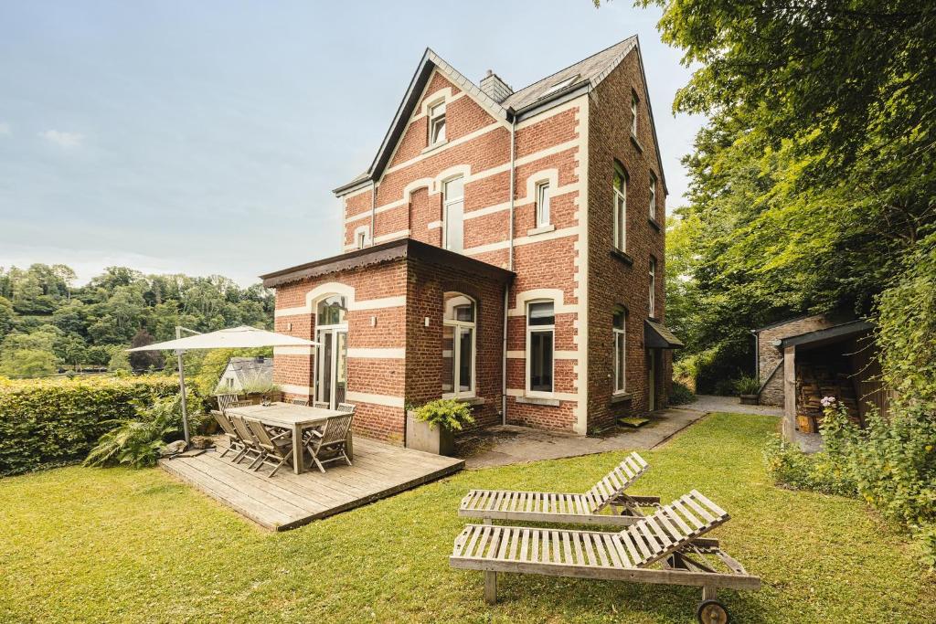 a brick building with a table and benches in the yard at Villa Louise in Durbuy