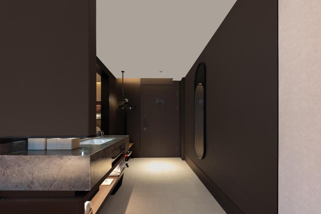 Atour Hotel Hohhot Wanda Plaza, Xinhua Street في هوهوت: مطبخ بجدران سوداء وحوض وطاولة