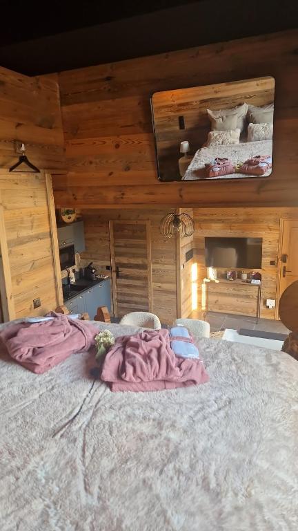 a large bed in a room with wooden walls at Charmante escapade in Baccarat