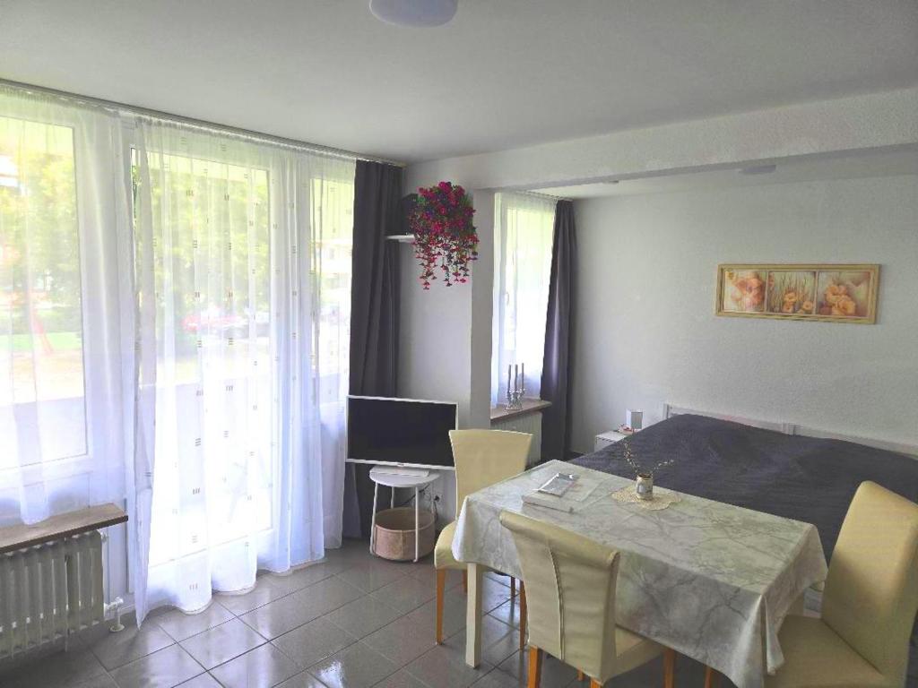a living room with a table and chairs and windows at Ruhige Ferienwohnung in Linden