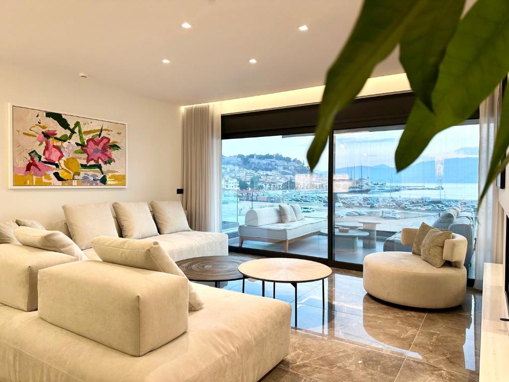 a living room with white furniture and a large window at FOS Luxury Apartment with View of Nafplio in Nafplio