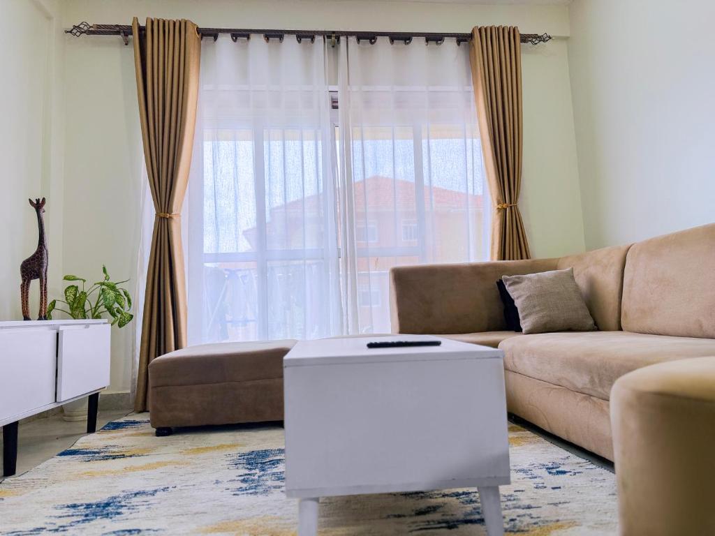 una sala de estar con un sofá y una mesa en FG Homes Kampala, Muyenga-Bukasa Road, en Kampala