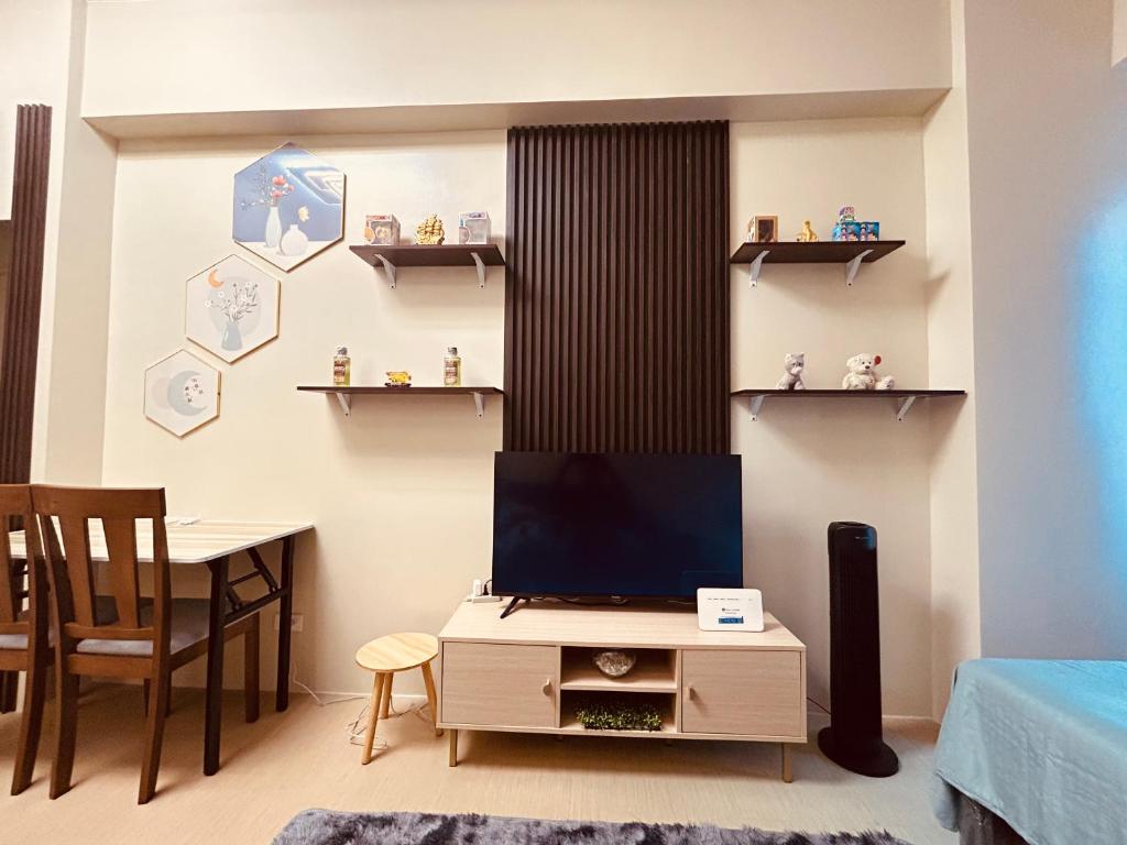 sala de estar con TV y escritorio con silla en Iloilo Staycation, en Iloilo City