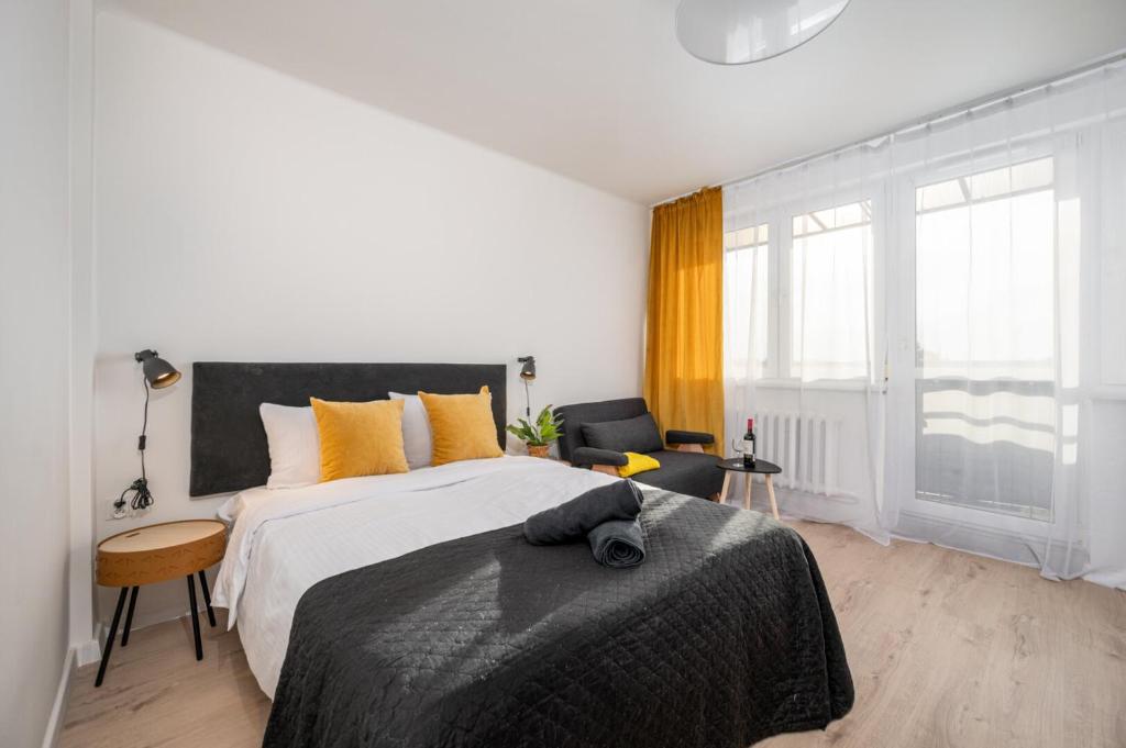 Un dormitorio blanco con una cama grande y una silla. en Gliwicka Premium Apartament z balkonem, en Rybnik