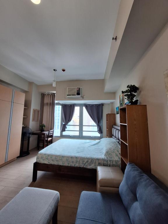ein Schlafzimmer mit einem Bett und einer Couch in der Unterkunft Eastwood Legrand3 Studio Type condo in Manila