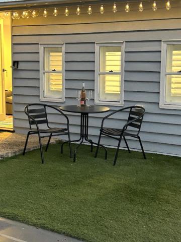 two chairs and a table in front of a house at Cozy guest suite in Margate, 200 mts from beach in Woody Point