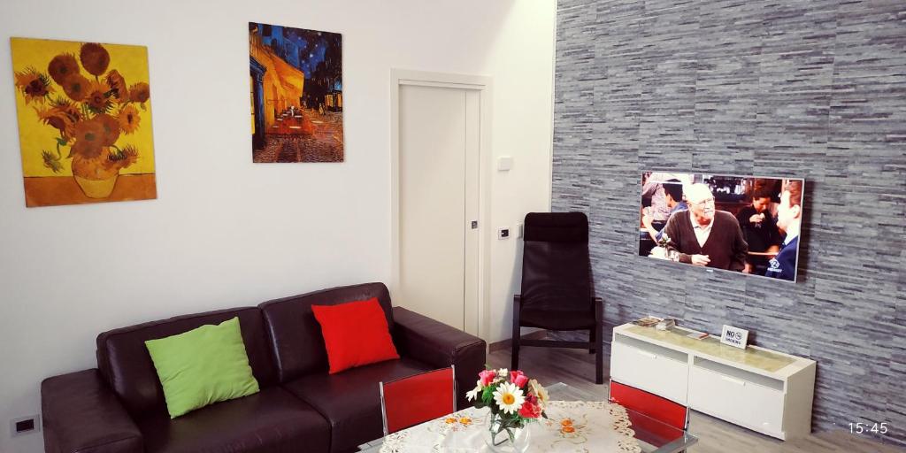 Hotel Apartment Sigaba, a living room with a brown couch and a brick wall at Apartment Sigaba in Milan