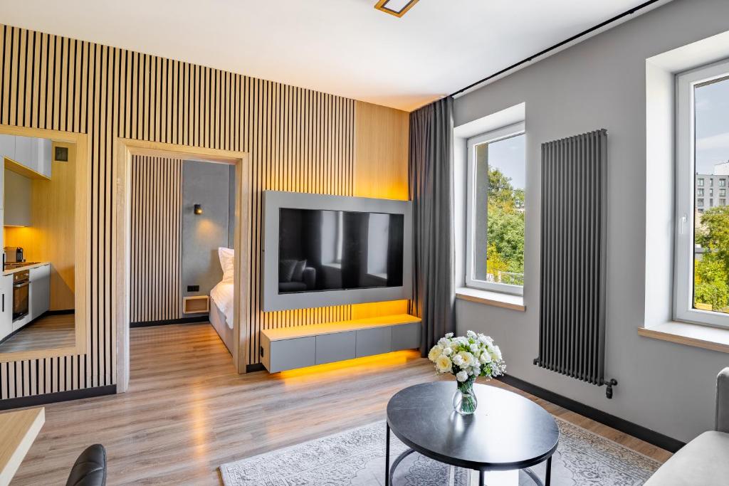 a living room with a television and a couch at SKY Home- Piwna Wood -Manufaktura, Parking, Dostęp na Kod in Łódź