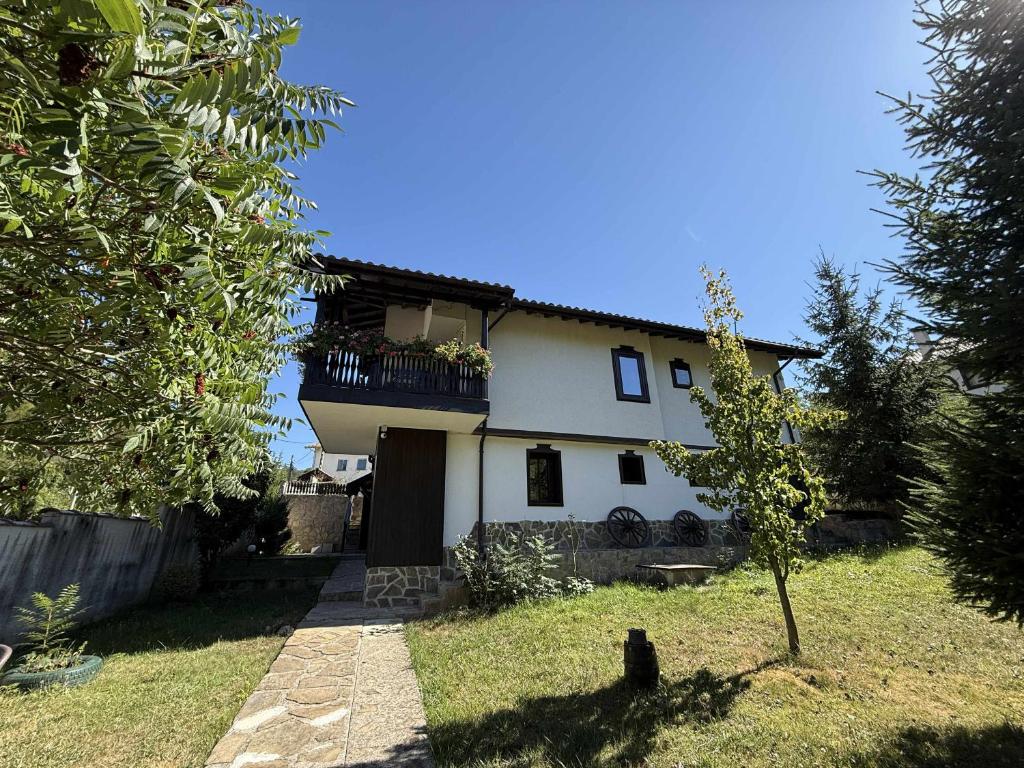 Casa bianca con balcone e albero di Къща за гости Сияйна Зора a Plachkovtsi