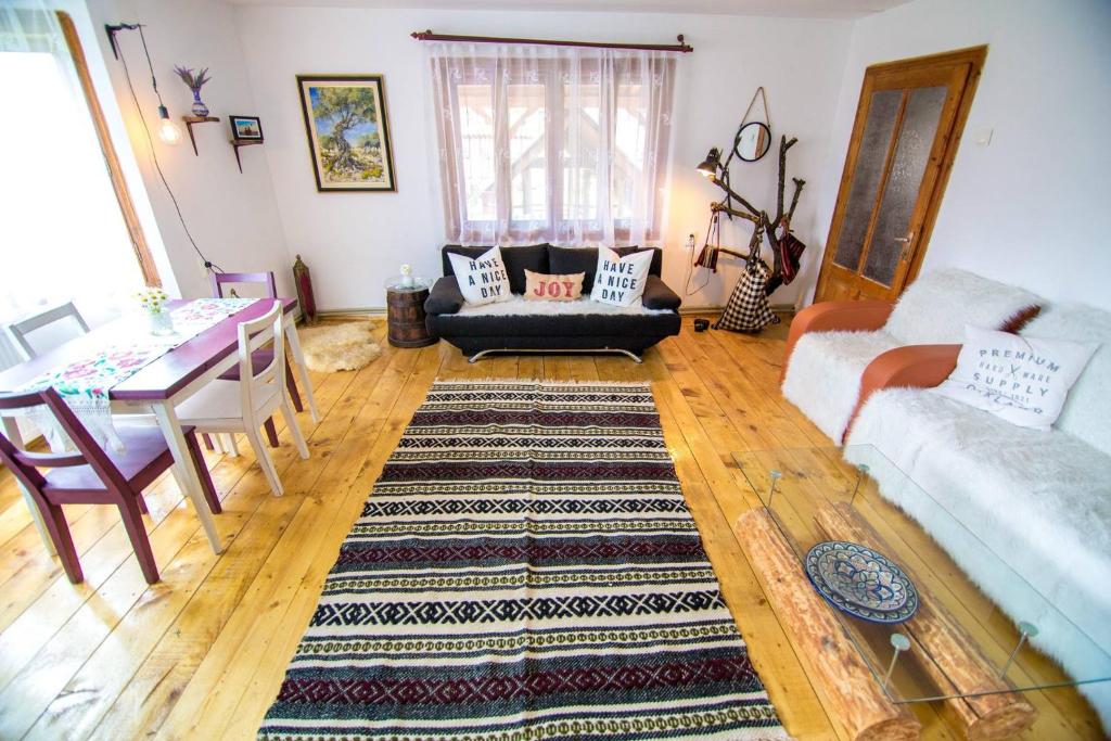 a living room with two couches and a table at Aura's Guest House in Sadova