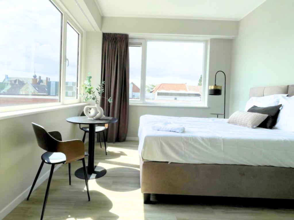 ein Schlafzimmer mit einem Bett und einem Tisch und einem Fenster in der Unterkunft Comfortable Room in Raamsdonksveer, Free Parking in Raamsdonksveer