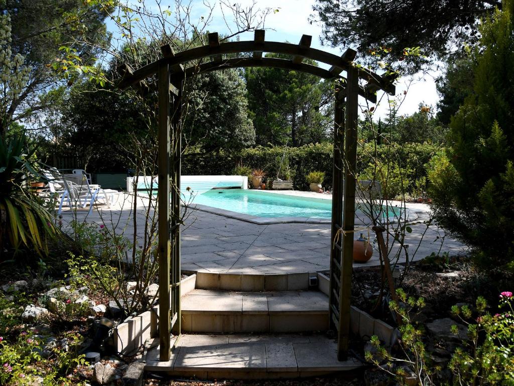 un arco que conduce a una piscina en un patio en Les chambres d'Adeline - B&B, en Murs